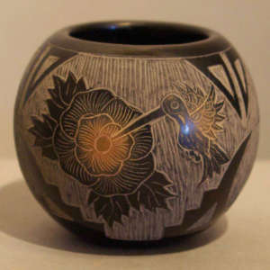 Sgraffito floral, hummingbird and geometric design on a black jar with sienna spots
