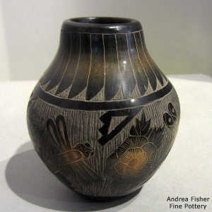 Sgraffito flower, dragonfly, feather and geometric design on a black jar with sienna spots