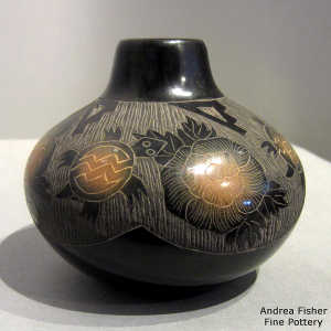 Sgraffito turtle, flower and geometric design on a black jar with sienna spots