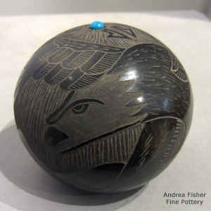 An inlaid stone and sgraffito eagle and geometric design on a black jar