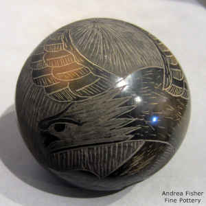 Sgraffito eagle and rock design on a black seed pot with sienna spots