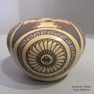 Storm cloud medallion, feather and geometric design on a polychrome seed pot
