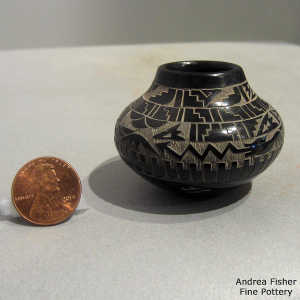 Sgraffito feather, avanyu and geometric design on a miniature black jar