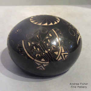Sgraffito moth and feather design on a black seed pot