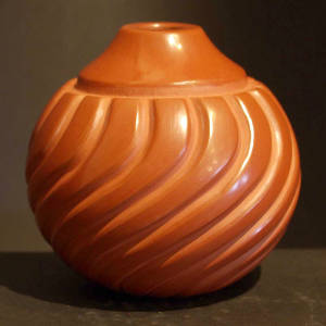 Carved swirl melon ribs on a polished red jar