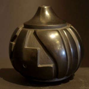 Fish, parrot and melon design carved into a narrow-necked black jar