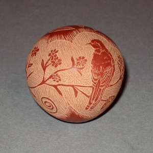 Sgraffito bird, flowering bush and geometric design on a red seed pot