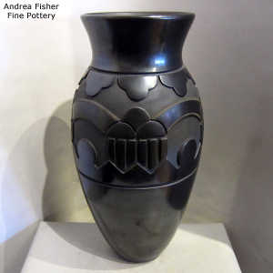 Rainbow, cloud and geometric design carved into a large black jar