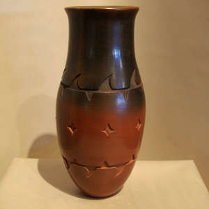 Geometric designs carved into a brown jar with sienna base