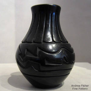 Feather and avanyu design carved into a tall neck black vase