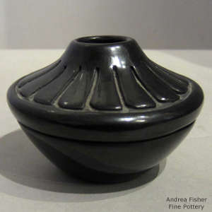 Feather design carved into a polished black jar