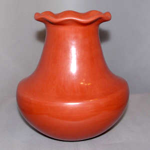 A fluted rim on a tall red jar