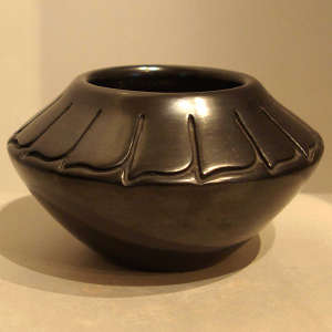 Feather design carved into a black jar