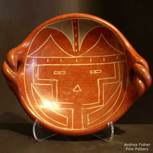 Twisted handles and sunface design on a shallow red bowl