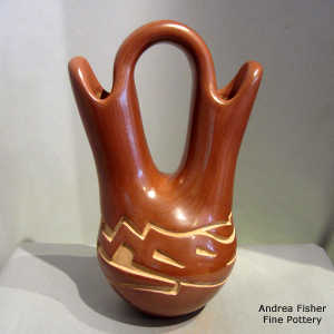 An avanyu design carved into a red wedding vase