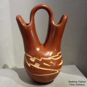 An avanyu design carved into a red wedding vase
