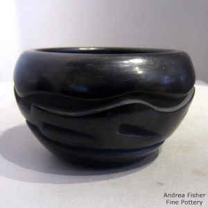 An avanyu design carved into a black bowl