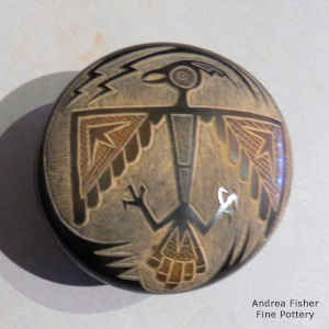 Sgraffito thunderbird and geometric design on a miniature black seed pot with sienna spots