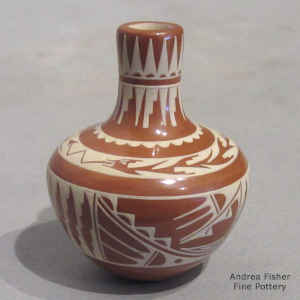 An avanyu and geometric design on a miniature red and white seed pot