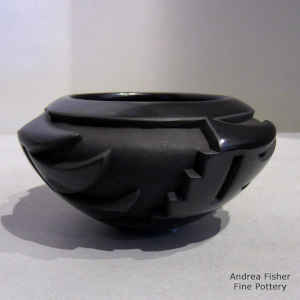 A 4-panel geometric design carved into a black on black bowl