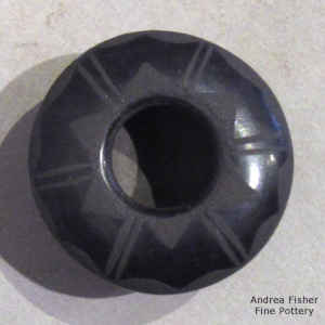 Miniature black on black jar decorated with a geometric design above the shoulder