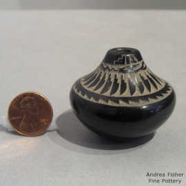 Miniature black jar decorated with a sgraffito avanyu, feather and geometric design
