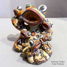 Five young frogs sitting on an elder frog storyteller