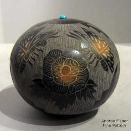 Sgraffito floral, feather, butterfly and geometric design on a black seed pot with an inlaid stone and sienna spots