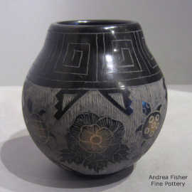 Sgraffito turtle, scroll, flower and geometric design on a black jar with sienna spots