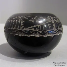 A sgraffito feather, avanyu and geometric design on a small black jar