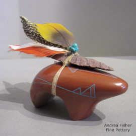 Sgraffito and painted geometric design on a red bear figure plus an arrowhead and a feather tied on its back