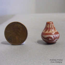 Sgraffito avanyu and feather design on a miniature red jar