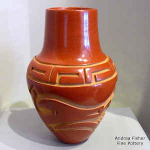 Red jar with a carved avanyu design