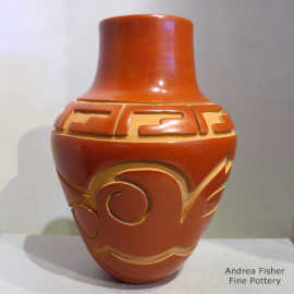 Red jar decorated with a carved avanyu design