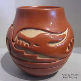 An avanyu designed carved into a red jar