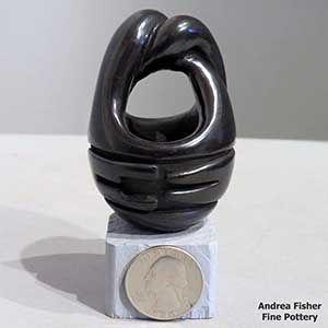 A geometric design carved into a black friendship basket with twisted handles