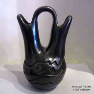 An avanyu design carved into a black wedding vase