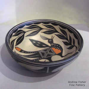 Bird, branch and geometric design inside and geometric design outside on this polychrome bowl