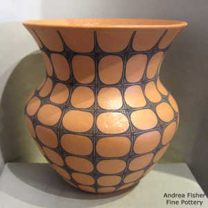 Black geometric design on a golden micaceous jar