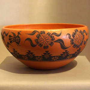 Bird, floral and geometric designs on an orange micaceous bowl