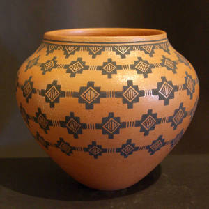 Bands of geometric designs decorate a golden micaceous jar