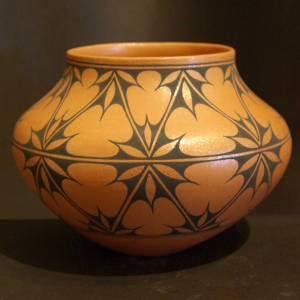 Black snowflake pattern on a golden micaceous jar