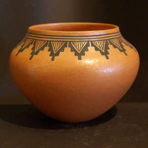 Band of geometric designs around the rim of a golden micaceous bowl