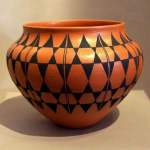 Black geometric design on a golden micaceous jar
