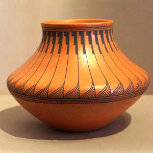 Feather and geometric design on an orange micaceous clay jar