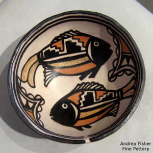 Geometric design outside and fish and geometric design inside on a polychrome bowl