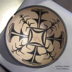 Handprint and geometric design inside a polychrome bowl with a geometric design on the outside