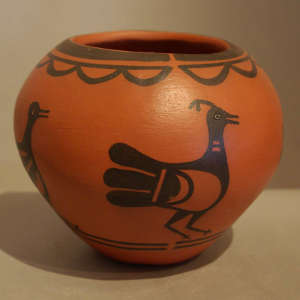 Bird and geometric designs on a black on red jar
