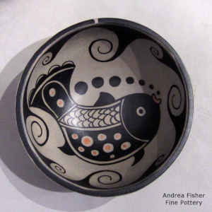 Fish and wave design inside, wave design outside on a polychrome bowl