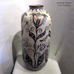 A flower, draonfly and geometric design on a polychrome jar